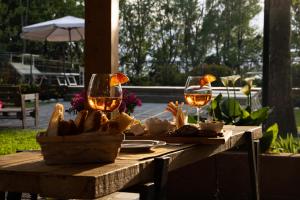 a table with two glasses of wine and food on it at Vecchio Granaio in Pisa