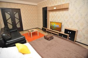 a bedroom with a large bed and a television at Apartment on Lva Tolstogo 14G in Kursk