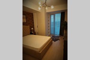 a bedroom with a bed and a large window at Prime location, Sea view flat near the Beach in Constanţa
