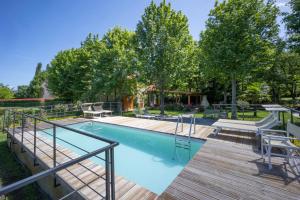 a swimming pool with a wooden deck next to a wooden deck at Vecchio Granaio in Pisa
