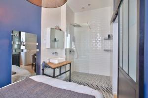 een badkamer met een douche, een wastafel en een bed bij CMG - Rouen Rive Droite - Gare in Rouen
