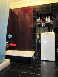 a bathroom with a black tiled floor and a bath tub at ARIOSTEA Ap.1 in Ferrara