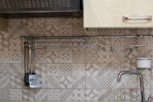 ein Bad mit einem Waschbecken und einer Fliesenwand in der Unterkunft MEDUSA Residence B&B in Margherita di Savoia