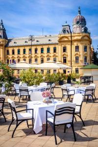
a large building with tables and chairs in front of it at Esplanade Zagreb Hotel in Zagreb
