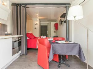 een keuken met een tafel en rode stoelen in een kamer bij Gîte Nantes, 1 pièce, 2 personnes - FR-1-306-1182 in Nantes