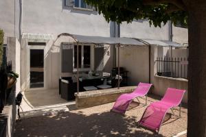 two pink chairs and a desk in a yard at Maison tendance avec jardin, centre village, Alpilles, familles in Eyragues