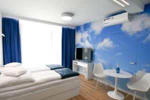 a bedroom with a bed and a tv and a table at Blue Sky Apartments Rezydencja Niechorze in Niechorze