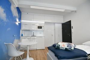 a bedroom with a bed and a table and a kitchen at Blue Sky Apartments Rezydencja Niechorze in Niechorze
