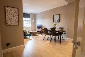 a dining room and living room with a table and chairs at Deluxe Modern 1&2 Bed Apartments Near Brighton Beach & Station in Brighton & Hove