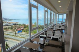 ein Konferenzraum mit Tischen, Stühlen und Fenstern in der Unterkunft Şimal Hotel in Rize