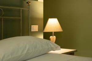 a lamp sitting on a table next to a bed at Vecchio Granaio in Pisa
