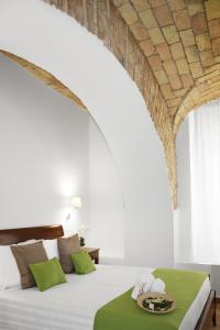 1 dormitorio con 1 cama grande y mesa verde en Roma Resort Colosseum en Roma