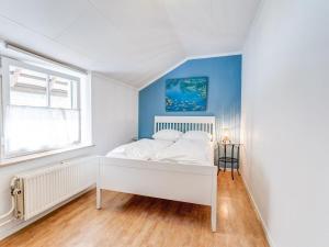 een slaapkamer met een wit bed en een raam bij Fine apartment with stunning views in Ubachsberg