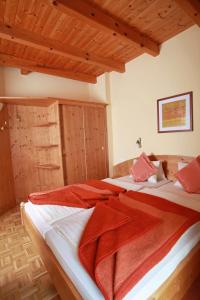 Kirchbach的住宿－舒斯特爾旅館，一间卧室配有两张带红色毯子的床。