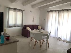 a kitchen and living room with a white table and chairs at Giorgia&Greta- relax casa vacanze in Olbia