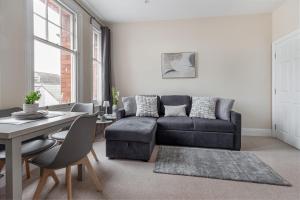 uma sala de estar com um sofá e uma mesa em Guest Homes - Trinity Apartment em Worcester