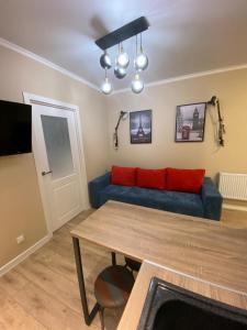 a living room with a blue couch and a table at Люкс исы байзакова 133 in Pavlodar