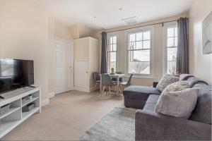 uma sala de estar com um sofá, uma televisão e uma mesa em Guest Homes - Trinity Apartment em Worcester