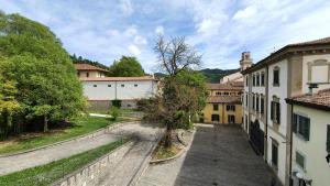 a view of a courtyard with a tree and buildings at Ostello Antica Filanda in Santa Sofia