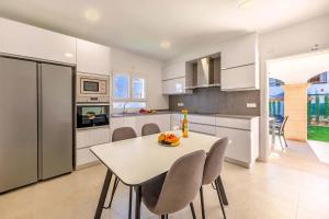 eine Küche mit einem Tisch und Stühlen in einer Küche in der Unterkunft Villa Amfora by Sealand Villas in Port d'Alcúdia