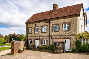 een groot bakstenen gebouw met witte deuren en ramen bij The Old Store Guest House in Chichester