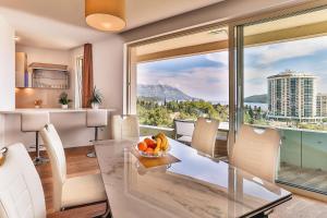 a kitchen with a table with a bowl of fruit on it at Lux Panorama in Budva