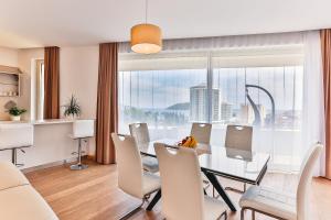 a dining room with a table and chairs and a large window at Lux Panorama in Budva