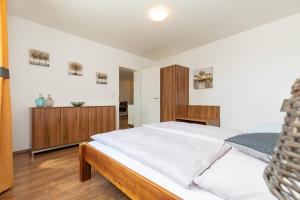 ein Schlafzimmer mit einem großen Bett mit weißer Bettwäsche in der Unterkunft Weingut-Ferienwohnung Münzenrieder in Apetlon