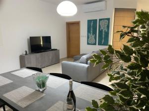 Sala de estar con mesa y botella de vino en Rock Bay, en Birżebbuġa