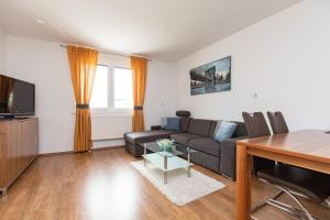 a living room with a couch and a tv at Weingut-Ferienwohnung Münzenrieder in Apetlon