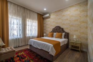 1 dormitorio con 1 cama grande y pared de ladrillo en NAR BOUTIQUE HOTEL en Baku