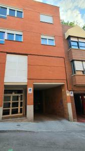 a red brick building with a large garage at habitación muy cerca del centro, en el metro 10min a sol/ gran vía in Madrid