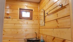 a bathroom with wooden walls and a sink at Земляничная поляна Боровое in Shchuchinskiy +141 photos