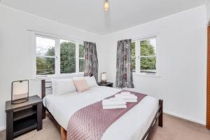a bedroom with a bed with two towels on it at Little Self-Contained 1BR w Netflix - Parking in Auckland
