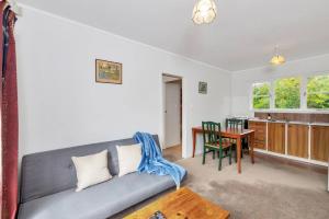 un soggiorno con divano e tavolo di Little Self-Contained 1BR w Netflix - Parking ad Auckland