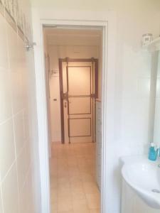 ein Bad mit einer Tür, die in ein Bad mit einem Waschbecken führt in der Unterkunft Casa Centurione Silvi Marina in Silvi Marina