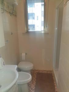 a bathroom with a toilet and a sink and a window at Casa Centurione Silvi Marina in Silvi Marina