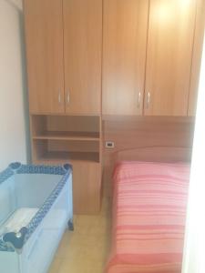 Schlafzimmer mit einem Bett und Holzschränken in der Unterkunft Casa Centurione Silvi Marina in Silvi Marina