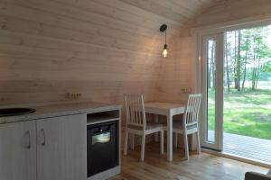 a kitchen with a table and chairs in a cabin at Natur Camp Birštonas in Birštonas