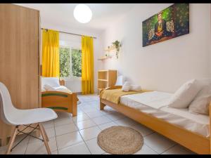 1 dormitorio con 1 cama, 1 silla y 1 ventana en Omalia Apartment en Prínos