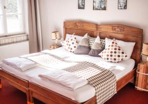 a bedroom with a large white bed with pillows at Naturschlosshotel Blumenthal in Aichach