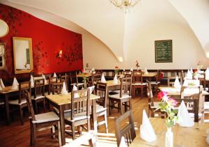 een restaurant met houten tafels en stoelen en een schoolbord bij Naturschlosshotel Blumenthal in Aichach