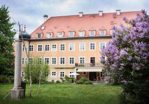 un grand bâtiment en briques avec un toit rouge dans l'établissement Naturschlosshotel Blumenthal, à Aichach