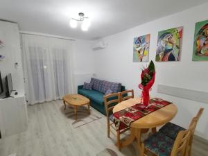 a living room with a table and a couch at Apartman Sofija in Banja Koviljača