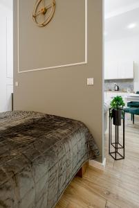 sypialnia z łóżkiem i zegarem na ścianie w obiekcie Niron Apartament Dom z Papieru Sztokholm w mieście Piła
