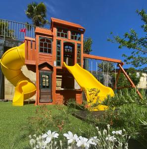a house with a slide in a yard with flowers at Hameau du Prat in Ribes