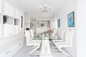 comedor con mesa de cristal y sillas blancas en Home2Book La Casita del Puerto, terrace & Pool, en Puerto de la Cruz