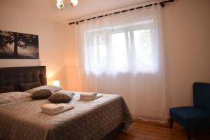 a bedroom with a bed and a window with towels on it at Apartment Tasha's Home in Opatija