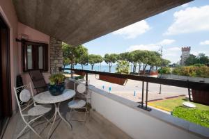 uma varanda com mesa e cadeiras e vista para o oceano em Splendid Lake em Desenzano del Garda