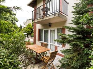 une terrasse avec une table et des chaises en bois devant un bâtiment dans l'établissement Karadağ Apart Hotel, à Büyükada